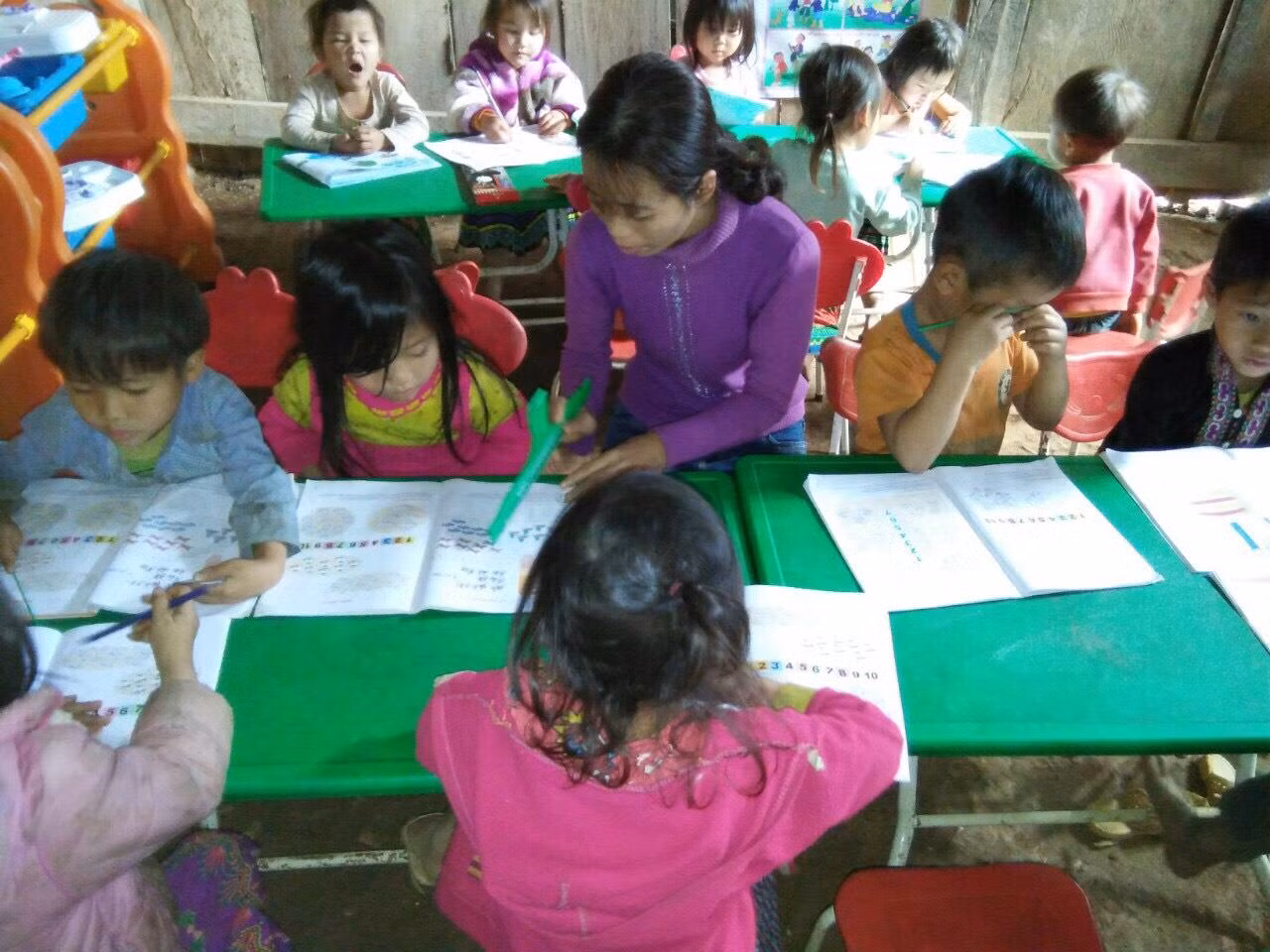 Học sinh được cô giáo hướng dẫn đọc và viết, nhiều trẻ đến lớp chưa nói được tiếng phổ thông, các em vẫn giao tiếp với cô bằng tiếng dân tộc. Ảnh: GVCC.