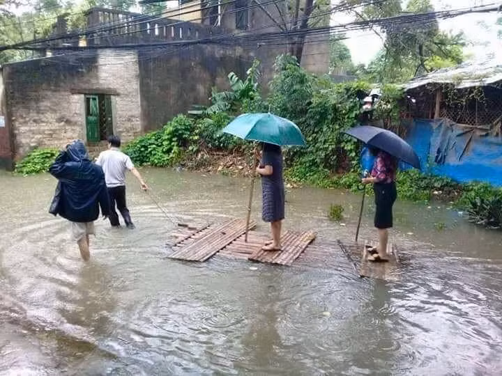Hình ảnh bà Nguyễn Thị Tâm, Chủ tịch ủy ban nhân dân phường Đông Thọ cùng cấp dưới đang đứng trên bè tự chế cho người khác kéo đi xem lũ