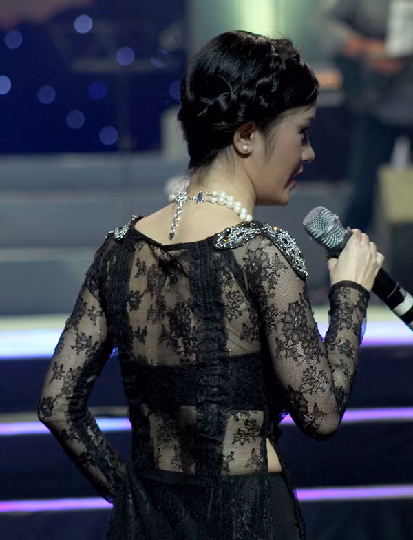 Nhìn từ phía sau, bộ áo ren nửa kín nửa hở của Hồng Nhung khiến trang phục áo dài mất đi nét thanh lịch, duyên dáng.(Nguồn: Ngoisao)