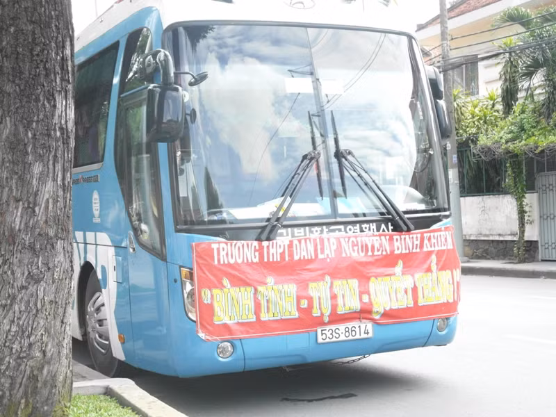 Khẩu hiệu quyết thắng trước đầu xe chờ học sinh đi thi, đậu trước Hội đồng thi trường Nguyễn Thị Minh Khai.