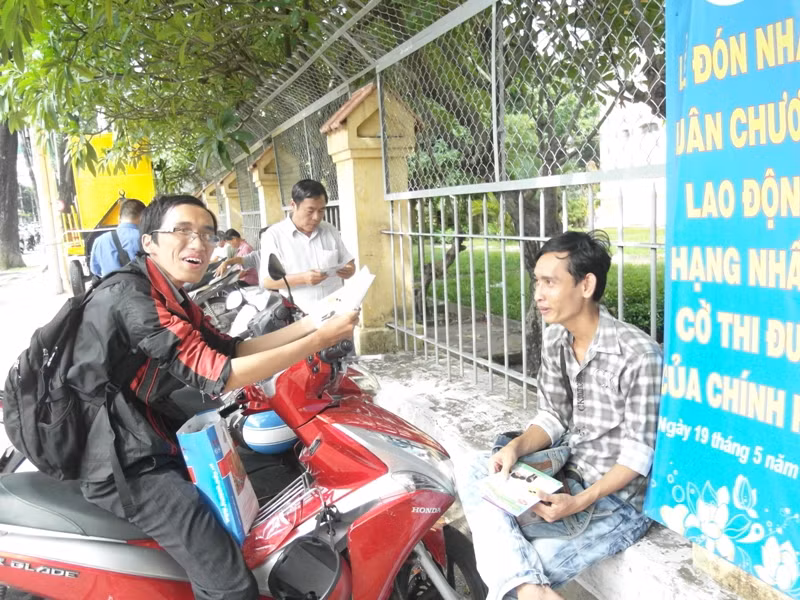 Hai sinh viên đang kiếm thu nhập bằng công việc phát tờ rơi, giới thiệu các trường Đại học, Cao đẳng... chờ giờ thi xong.