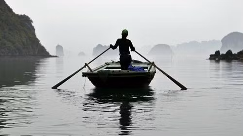 Dáng người phụ nữ chèo thuyền đưa đón khách du lịch đi tham quan các khu làng nổi trên Vịnh Hạ Long. Dáng người phụ nữ chèo thuyền đưa đón khách du lịch đi tham quan các khu làng nổi trên Vịnh Hạ Long.
