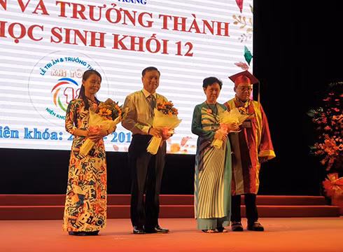 Học sinh khối 12 tặng hoa cảm ơn giáo viên, thầy Hiệu trưởng trong lễ tri ân, trưởng thành (ảnh: P.L)