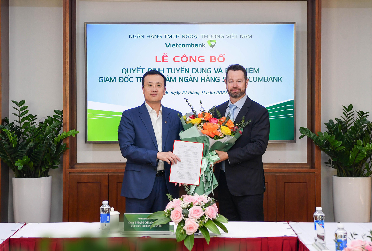 Ông Phạm Quang Dũng - Ủy viên Ban thường vụ Đảng ủy Khối Doanh nghiệp Trung ương, Bí thư Đảng ủy, Chủ tịch Hội đồng quản trị Vietcombank (bên trái) trao quyết định và tặng hoa chúc mừng tân Giám đốc Trung tâm ngân hàng số Vietcombank