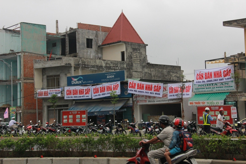 Nhiều người bất ngờ trước những tấm biển "cần bán nhà gấp" được treo lên trước ngày cầu vượt được khánh thành. Ảnh Thùy Linh