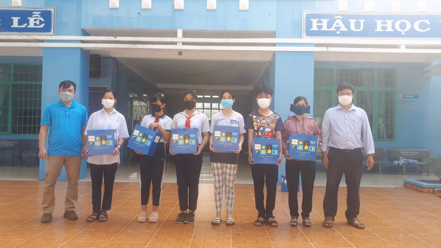 Thầy Đặng Văn Tuân (trái) Bí thư Chi bộ và thầy Phan Văn Trinh (phải) phó hiệu trưởng tặng quà Tết cho học sinh