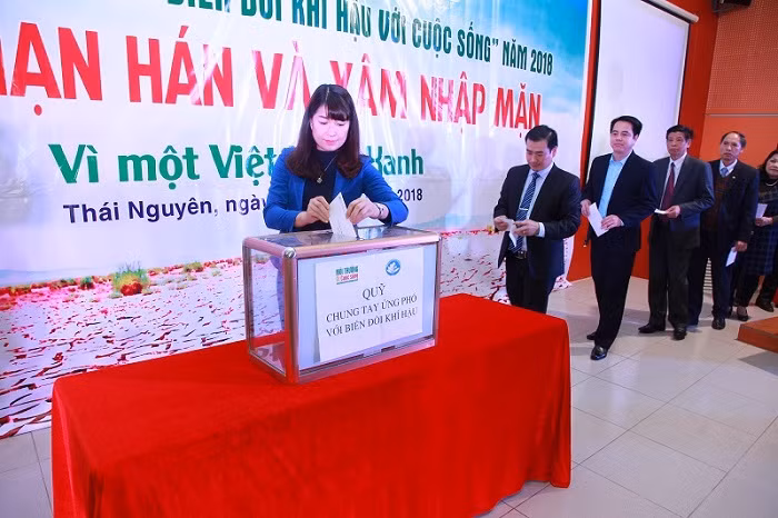 Các vị đại biểu và cán bộ, sinh viên trong trường cùng gây quỹ “Chung tay ứng phó với biến đổi khí hậu”.