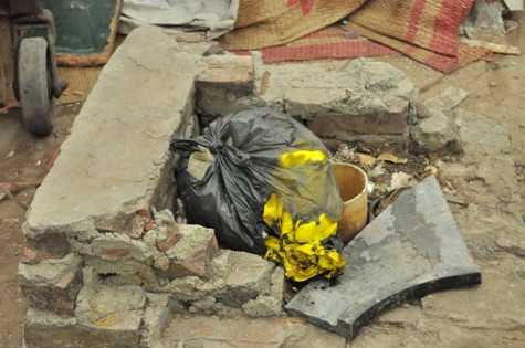 Đống vải vàng trong chiếc túi nilon màu đen quấn cháu bé khi mới được phát hiện Đống vải vàng trong chiếc túi nilon màu đen quấn cháu bé khi mới được phát hiện