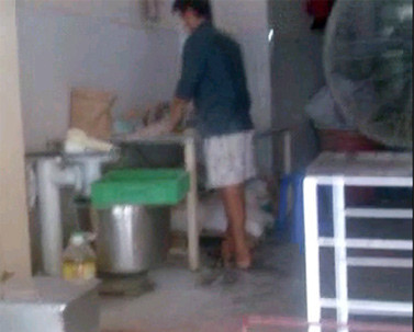 Nhân viên tay không nặn bánh, không khẩu trang và đồng phục lao động.