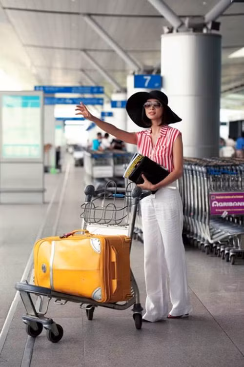 Ngô Thanh Vân với style sân bay cực đẹp, quần trắng dài và áo sơ mi sọc kẻ nổi bật. (Theo Eva)