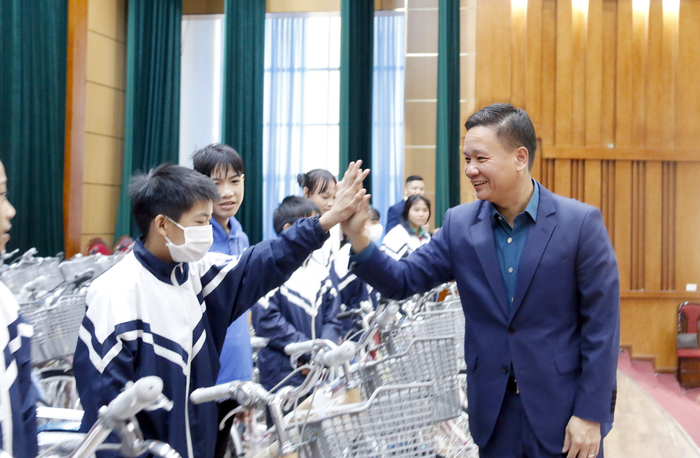 Nhà báo Nguyễn Tiến Bình trao tặng xe đạp và đập tay động viên các em học sinh. Nhà báo Nguyễn Tiến Bình trao tặng xe đạp và đập tay động viên các em học sinh.