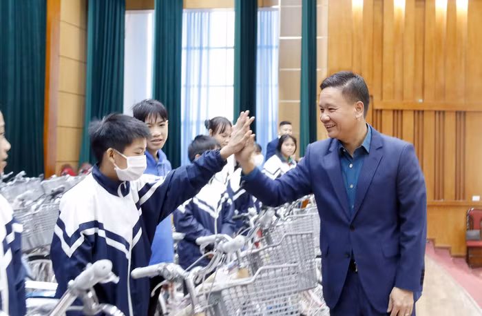 Nhà báo Nguyễn Tiến Bình trao tặng xe đạp và đập tay động viên các em học sinh. Nhà báo Nguyễn Tiến Bình trao tặng xe đạp và đập tay động viên các em học sinh.