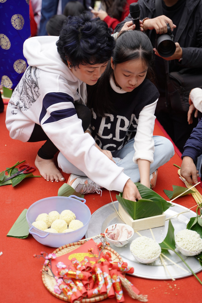 Cô Văn Thùy Dương - Phó Hiệu trưởng Trường Lương Thế Vinh hướng dẫn học trò gói bánh chưng