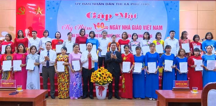 Nhà báo Nguyễn Tiến Bình (áo vest) - Phó Chủ tịch Hiệp hội Các trường đại học, cao đẳng Việt Nam kiêm Tổng Biên tập Tạp chí điện tử Giáo dục Việt Nam và lãnh đạo thị xã Phú Thọ trao thưởng cho 40 giáo viên có hoàn cảnh khó khăn nhưng đã nỗ lực vươn lên hoàn thành xuất sắc các nhiệm vụ của ngành trong năm học 2021-2022, tổng số tiền 120 triệu đồng.