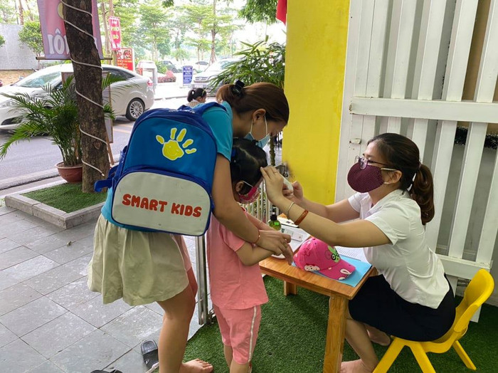 Các bé đến trường cũng được các cô giáo đón và đo thân nhiệt trước khi vào lớp (ảnh nguồn cơ sở giáo dục mầm non Bé Thông Minh). Các bé đến trường cũng được các cô giáo đón và đo thân nhiệt trước khi vào lớp (ảnh nguồn cơ sở giáo dục mầm non Bé Thông Minh).