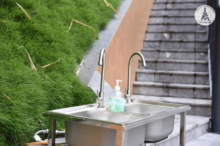 Tổ Vệ sinh triển khai tổng vệ sinh toàn bộ khuôn viên trường; làm sạch bàn ghế, trang thiết bị lớp học, chăn gối để đảm bảo an toàn, mang đến không gian sạch sẽ, trong lành cho học sinh khi quay lại trường.