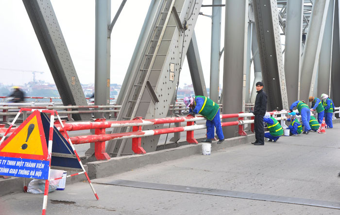 Nhân viên đội quản lý cầu Chương Dương của Công Ty Công Trình Giao Thông Vận Tải đang sơn lại thành cầu Chương Dương.