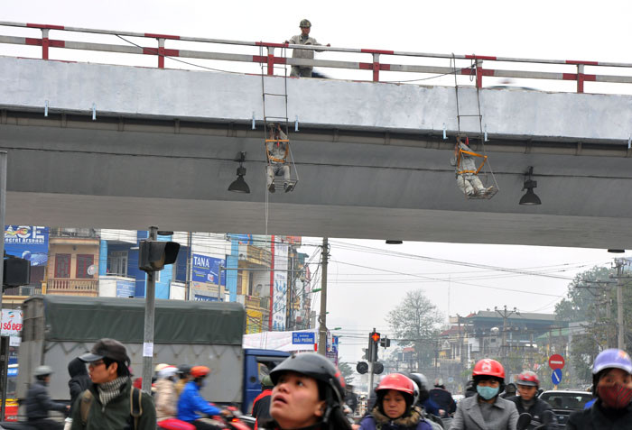 Công nhân đang chuẩn bị nắp ghép những biển báo mới trên cầu vượt Giải Phóng.