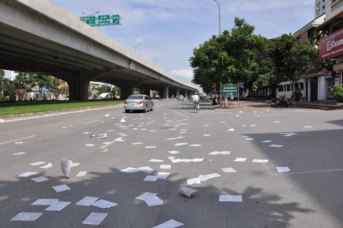 Giấy rơi xuống đường và lan ra theo chiều gió.