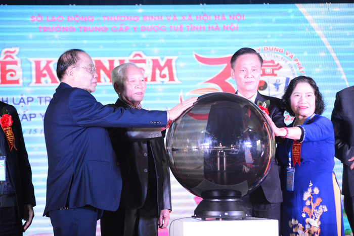 Lãnh đạo nhà trường cùng đặt tay lên quả cầu đánh dấu mốc kỷ niệm 30 năm thành lập trường. Ảnh: Trà My