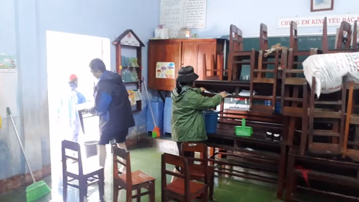 Bàn ghế kê lên tránh lũ được đưa xuống để chuẩn bị cho học sinh vào học.