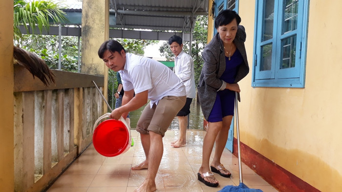 Dùng nước để tẩy rửa hành lang lớp học bị bùn bám đặc. Dùng nước để tẩy rửa hành lang lớp học bị bùn bám đặc.