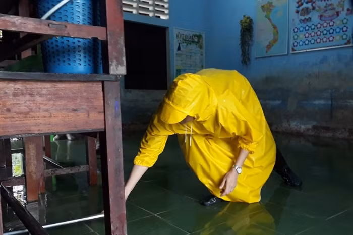 Dùng chổi để lau nền lớp học.