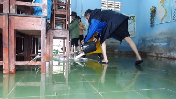 Giáo viên trường Tiểu học số 1 Quảng Vinh dùng nước làm sạch nền nhà.