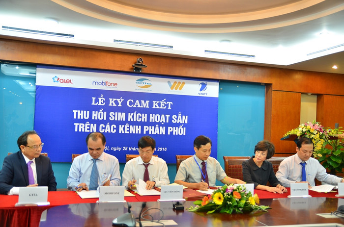 Đại diện 5 doanh nghiệp viễn thông và Cục Viễn thông ký cam kết thu hồi sim kích hoạt sẵn trên các kênh phân phối - Ảnh: H.Lực.