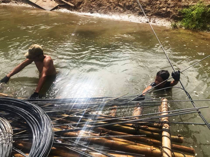 Vận chuyển vật liệu bằng bè vượt suối để xây dựng điểm trường lẻ Tăk Rối. Ảnh do NVCC Vận chuyển vật liệu bằng bè vượt suối để xây dựng điểm trường lẻ Tăk Rối. Ảnh do NVCC