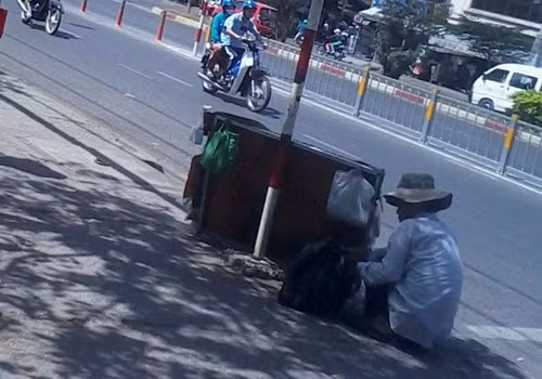 Một người đàn ông chuẩn bị "hàng" trước khi đi bán dạo tại bến xe Miền Tây.