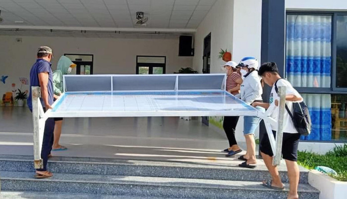 Giáo viên, phụ huynh, học sinh cùng tham gia di chuyển đồ dùng học tập để tránh bão.