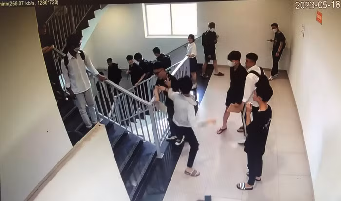 Nam sinh áo trắng lao vào đánh tới tấp vào đầu nam sinh L.T.C. Ảnh cắt từ clip.