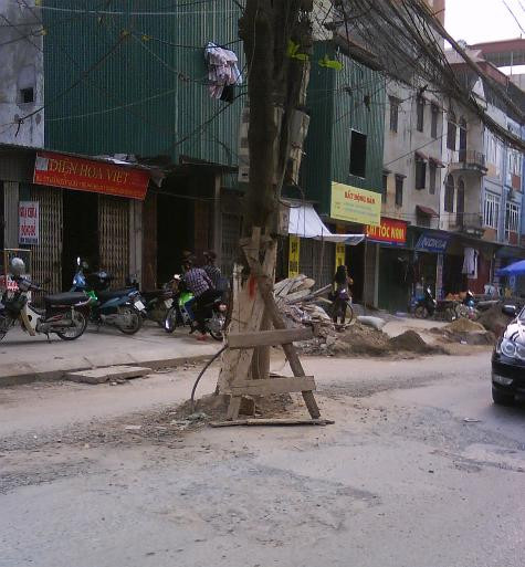 Đường Trần Quốc Hoàn - nơi chất chứa không ít mối nguy hiểm từ dãy cột điện mọc giữa đường, án ngữ lối đi lại của người dân. Đường Trần Quốc Hoàn - nơi chất chứa không ít mối nguy hiểm từ dãy cột điện mọc giữa đường, án ngữ lối đi lại của người dân.