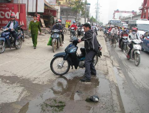 Chủ xe đang dắt xe vào vỉa hè chờ người thân đến giúp đỡ Chủ xe đang dắt xe vào vỉa hè chờ người thân đến giúp đỡ