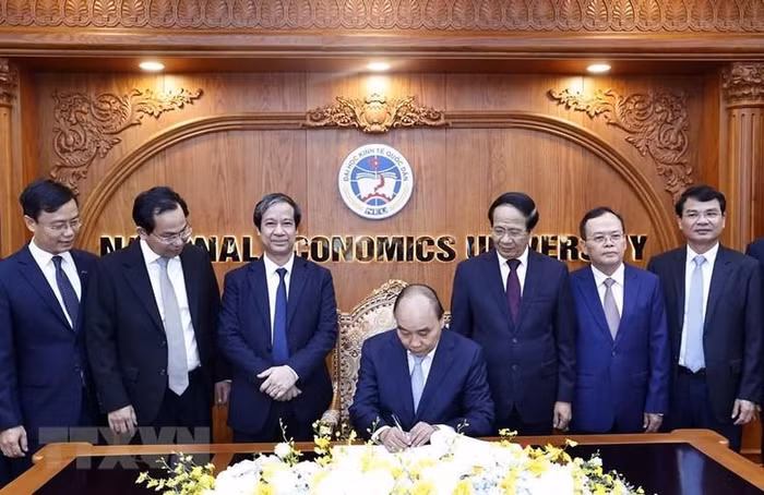 Chủ tịch nước Nguyễn Xuân Phúc viết lưu bút tại phòng truyền thống Trường đại học Kinh tế quốc dân. (Ảnh: Thống Nhất/TTXVN)