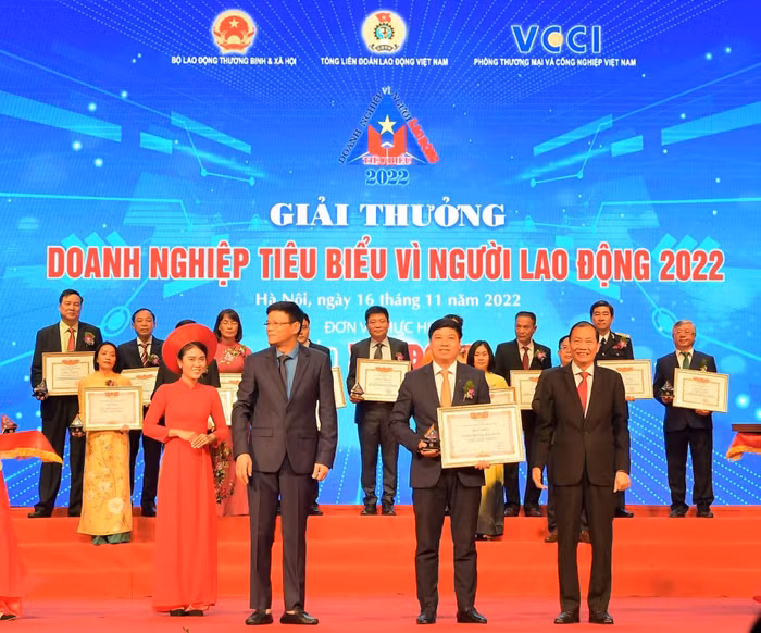 Ông Hoàng Quang Phòng - Phó Chủ tịch VCCI (bên phải) trao Bằng khen “Doanh nghiệp tiêu biểu vì người lao động” của VCCI và ông Nguyễn Ngọc Hiển - Ủy viên Đoàn Chủ tịch Tổng Liên đoàn Lao động Việt Nam, Tổng biên tập báo Lao Động (bên trái) tặng Kỷ niệm chương cho ông Hồng Quang - Thành viên Hội đồng quản trị kiêm Giám đốc Khối Nhân sự, Chủ tịch Công đoàn Vietcombank - đại diện Vietcombank.