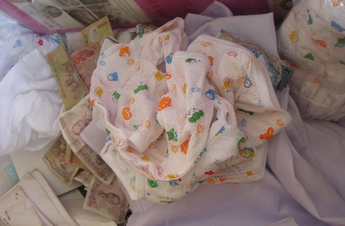 Số quần áo trẻ sơ sinh, vải trắng dùng để khâm niệm và tiền công đức của người dân làng Đồi Cốc tuy ít nhưng là tấm lòng chan chứa tình thương. Số quần áo trẻ sơ sinh, vải trắng dùng để khâm niệm và tiền công đức của người dân làng Đồi Cốc tuy ít nhưng là tấm lòng chan chứa tình thương.