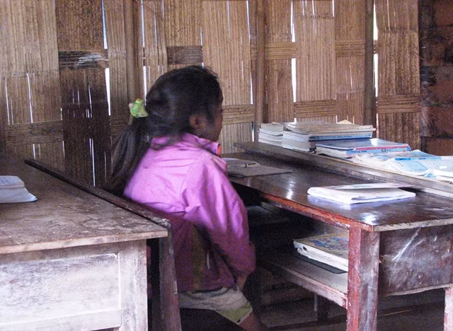 Trời mưa, học sinh ở bản Nồông cũ phải cho sách vở vào ngăn bàn không là bị ướt (Ảnh: Thủy Phan)