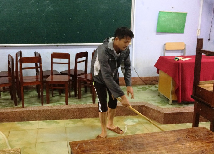 Nền nhà đầy bùn non được giáo viên lau dọn.