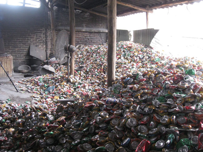 Từ cổng đến sân, nhà nào cũng chất ngồn ngộn những nắp chai lọ, vỏ hộp bẹp rúm. Từ cổng đến sân, nhà nào cũng chất ngồn ngộn những nắp chai lọ, vỏ hộp bẹp rúm.