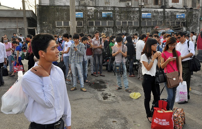 Sau khi mua vé vào bến, nhiều người phải đứng, ngồi để ngóng xe về bến