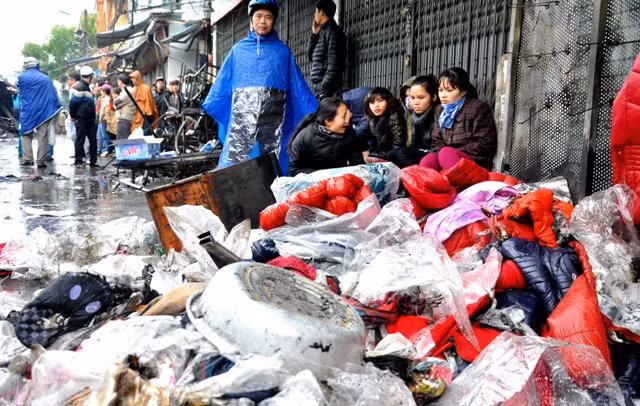 Tiểu thương đau đớn khi nhìn thấy sản phẩm buôn bán của mình bị cháy.