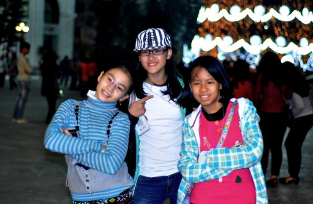 Những em học sinh cũng tạo dáng xì tin cùng cây thông.