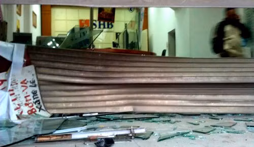 Cửa cuốn và cửa kính của một chi nhánh ngân hàng SHB bị vỡ nát.