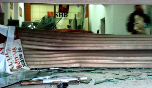 Cửa cuốn và cửa kính của một chi nhánh ngân hàng SHB bị vỡ nát. Cửa cuốn và cửa kính của một chi nhánh ngân hàng SHB bị vỡ nát.