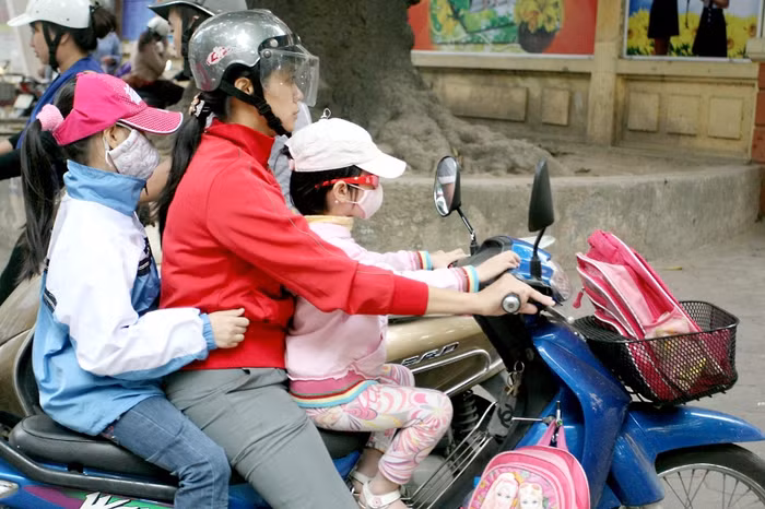 Mẹ chở con đi học cũng đầy đủ áo khoác, khẩu trang giữ ấm và tránh bụi