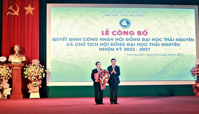 Phó giáo sư Nguyễn Văn Phúc – Phó Bí thư Ban Cán sự Đảng, Thứ trưởng Bộ Giáo dục và Đào tạo trao quyết định và tặng hoa chúc mừng Giáo sư Phạm Hồng Quang – Bí thư Đảng ủy, Chủ tịch Hội đồng Đại học Thái Nguyên (Ảnh: NTCC)