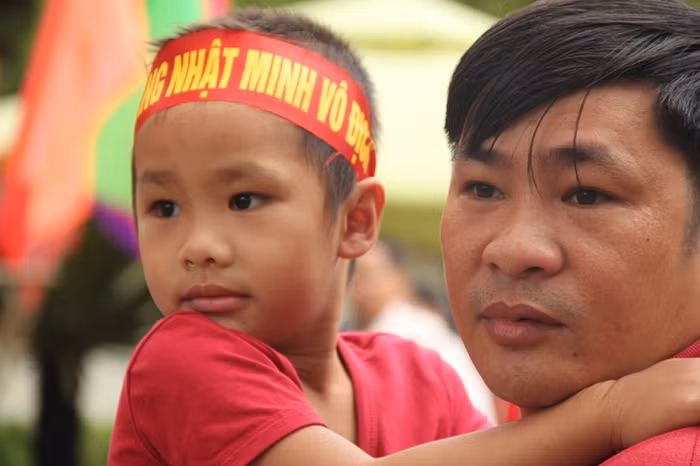 Một cổ động viên nhí theo ba đến trường cổ vũ cho Nhật Minh