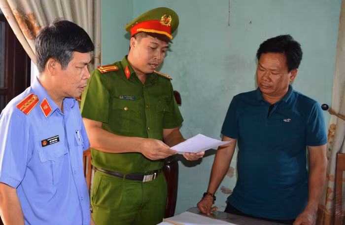 Công an tống đạt các quyết định đối với ông Lê Tự Trung. Ảnh: CTV